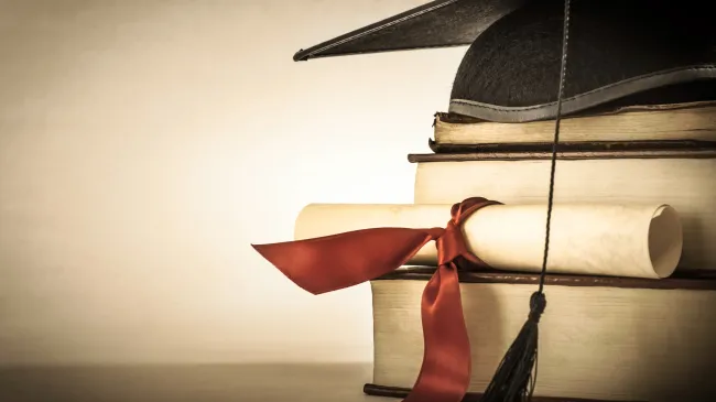 graduation cap on books